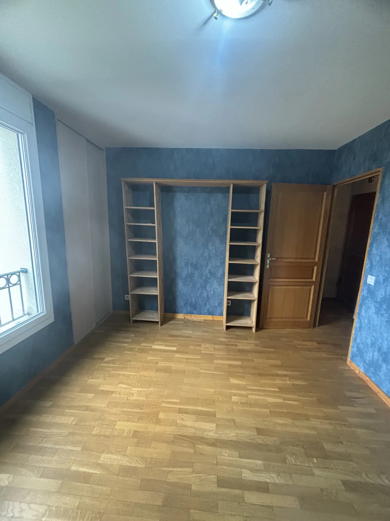 Chambre rénovée avec murs bleus et panneau décoratif